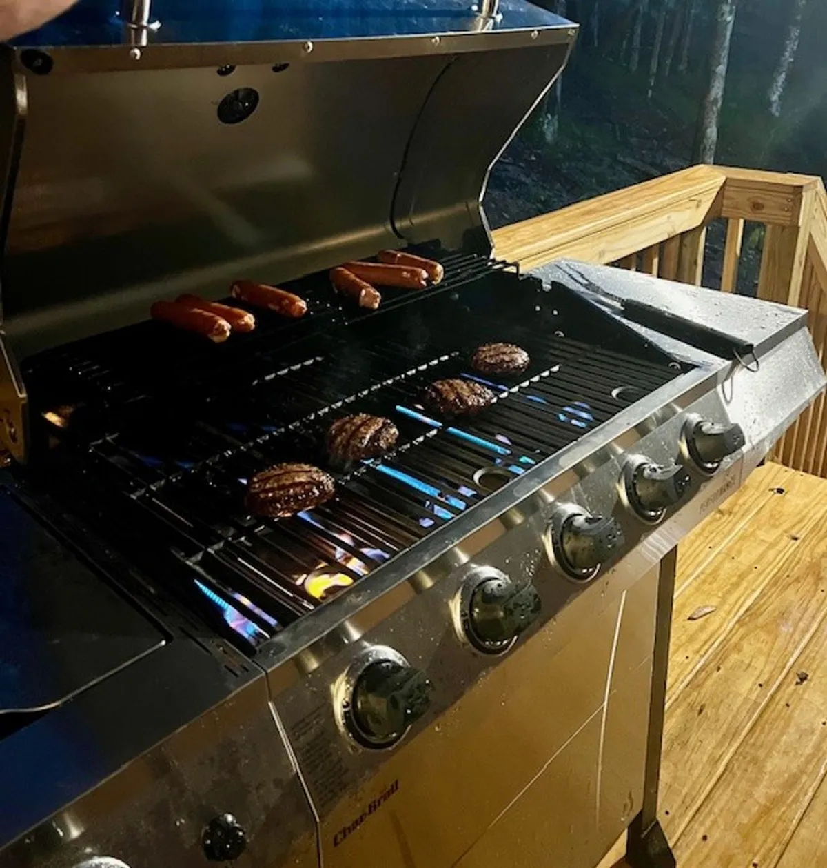 The lodge’s outdoor grill on the deck, with food sizzling and the forest in the background. This scene invites socializing, outdoor dining, and the creation of fun memories around shared meals.